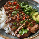 Tazón de pollo y arroz con aguacate, maíz y vegetales coloridos, visto de lado.