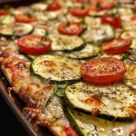 Un delicioso Zucchini-Tomaten-Auflauf con mozzarella derretida.