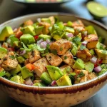 ['Close-up view of a vibrant avocado chicken salad with diced ingredients.', 'Juicy avocado chicken salad featuring colorful vegetables and herbs.', 'Side view of a fresh avocado chicken salad served in a bowl.', 'Healthy avocado and chicken salad displaying a mix of chopped ingredients.']